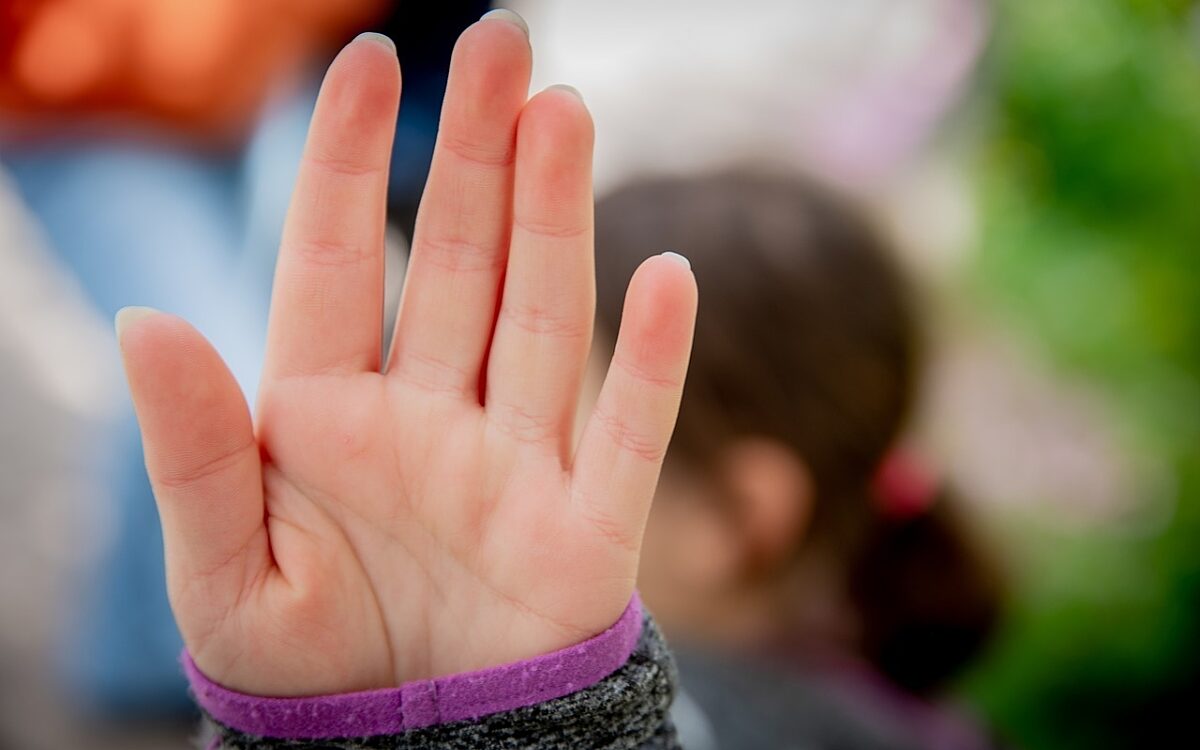 Junge frau streckt flache hand aus Junge frau streckt flache hand aus